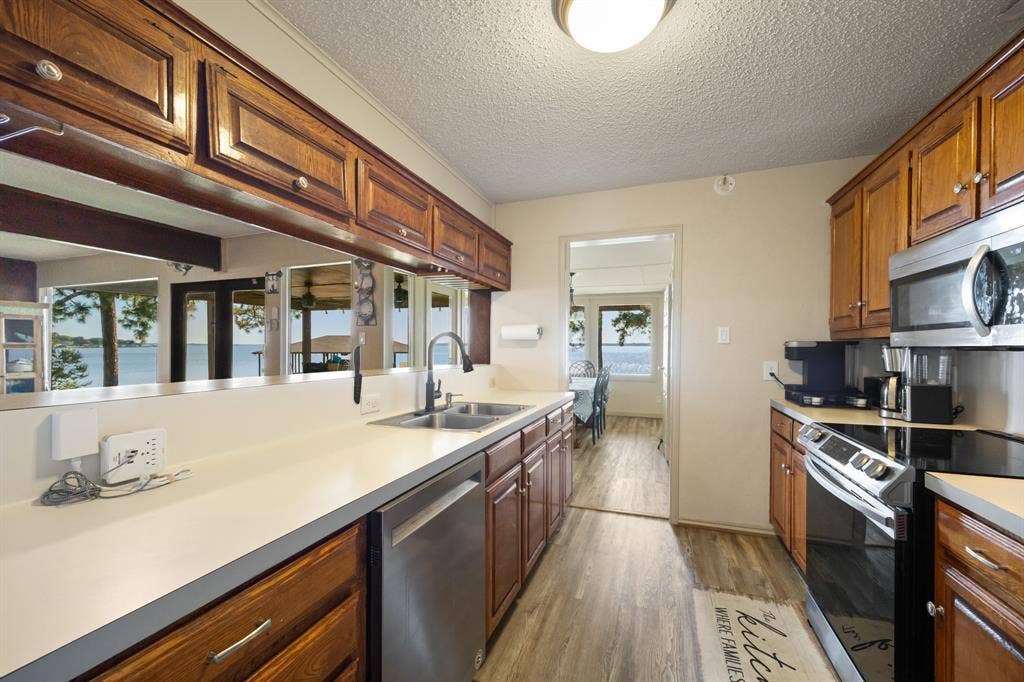Kitchen featuring wood cabinetry, light-toned countertops, and stainless steel appliances