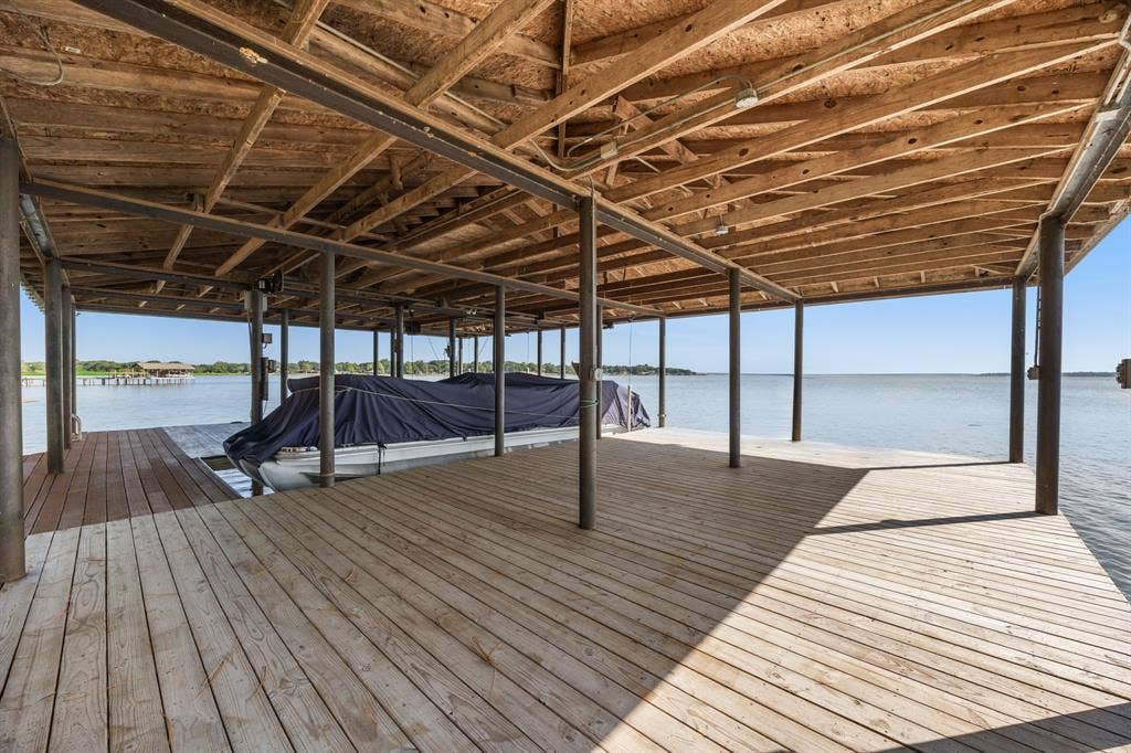 Expansive covered boat dock with a large deck area, durable wood planking, and steel support pilings
