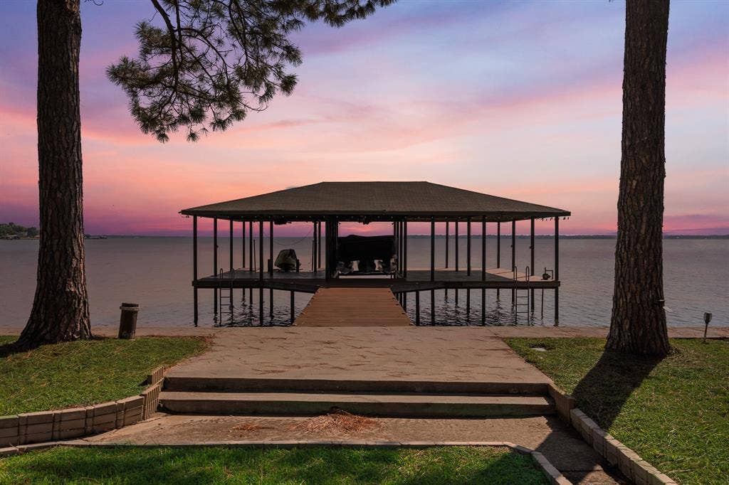 Covered boat dock featuring a wood deck and metal pilings