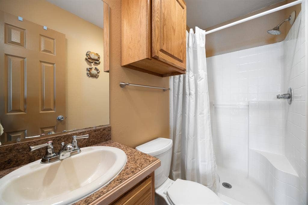 Bathroom featuring a vanity with an integrated sink, a speckled countertop, and chrome faucet
