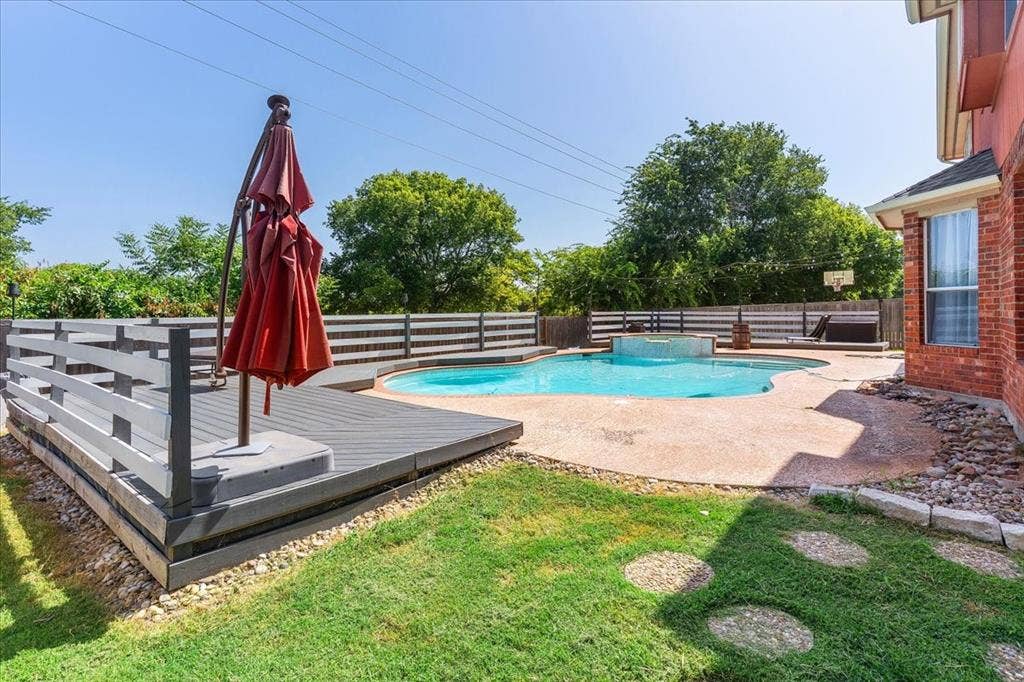 1013 Larkspur Drive, Allen, TX 75002 Backyard featuring a freeform swimming pool, integrated spa, and a composite deck with built-in railing