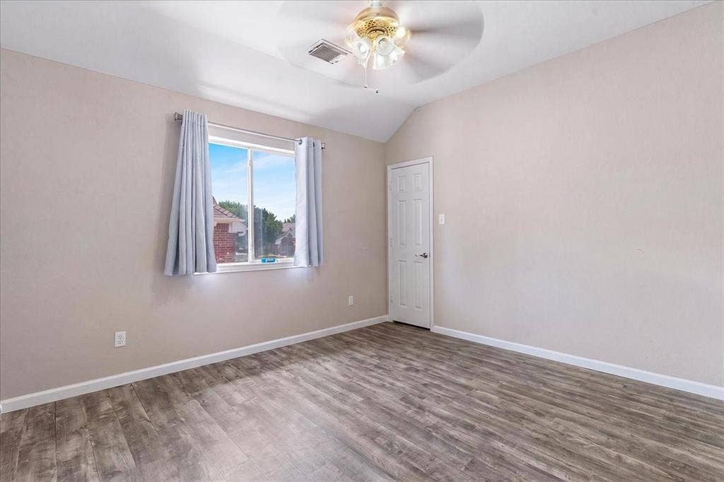 1013 Larkspur Drive, Allen, TX 75002 Spacious room featuring wood-finish flooring, a vaulted ceiling, and a ceiling fan with integrated lighting