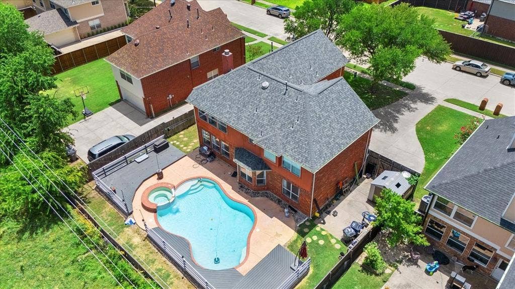 1013 Larkspur Drive, Allen, TX 75002 Brick exterior residence featuring a private backyard with a freeform swimming pool and integrated spa