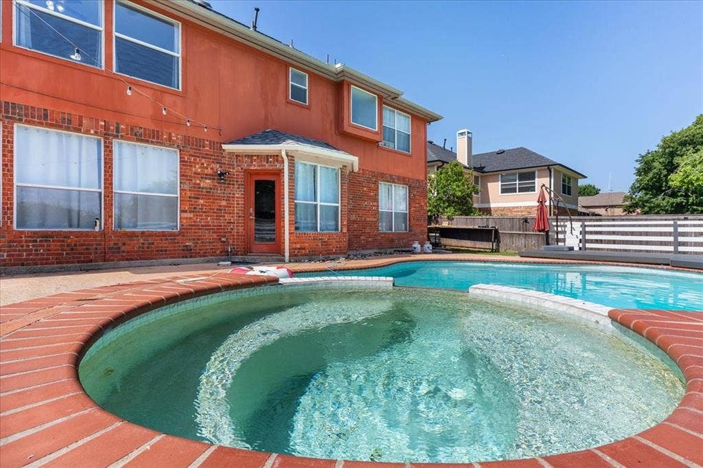 1013 Larkspur Drive, Allen, TX 75002 Outdoor living space featuring a brick-lined spa and swimming pool, surrounded by a concrete patio