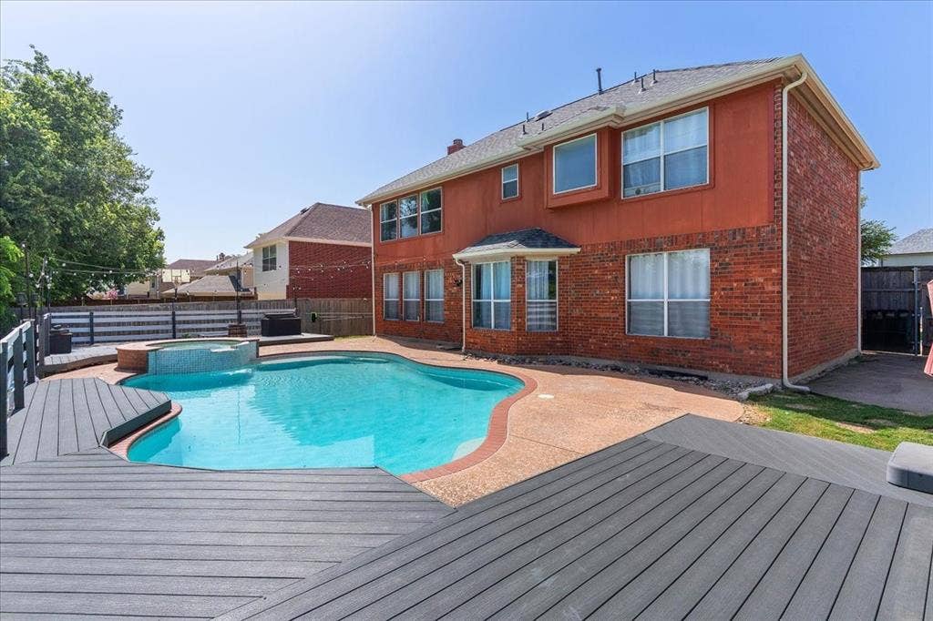 1013 Larkspur Drive, Allen, TX 75002 Backyard oasis featuring a freeform swimming pool, integrated spa, and expansive multi-level composite decking