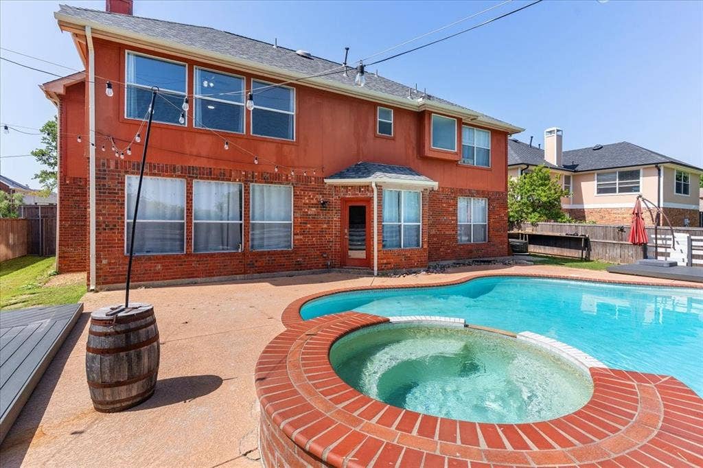 1013 Larkspur Drive, Allen, TX 75002 Spacious backyard featuring a freeform swimming pool and integrated hot tub with brick coping