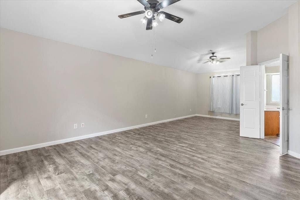 1013 Larkspur Drive, Allen, TX 75002 Spacious room featuring vaulted ceilings, wood-finish flooring, and multiple ceiling fans