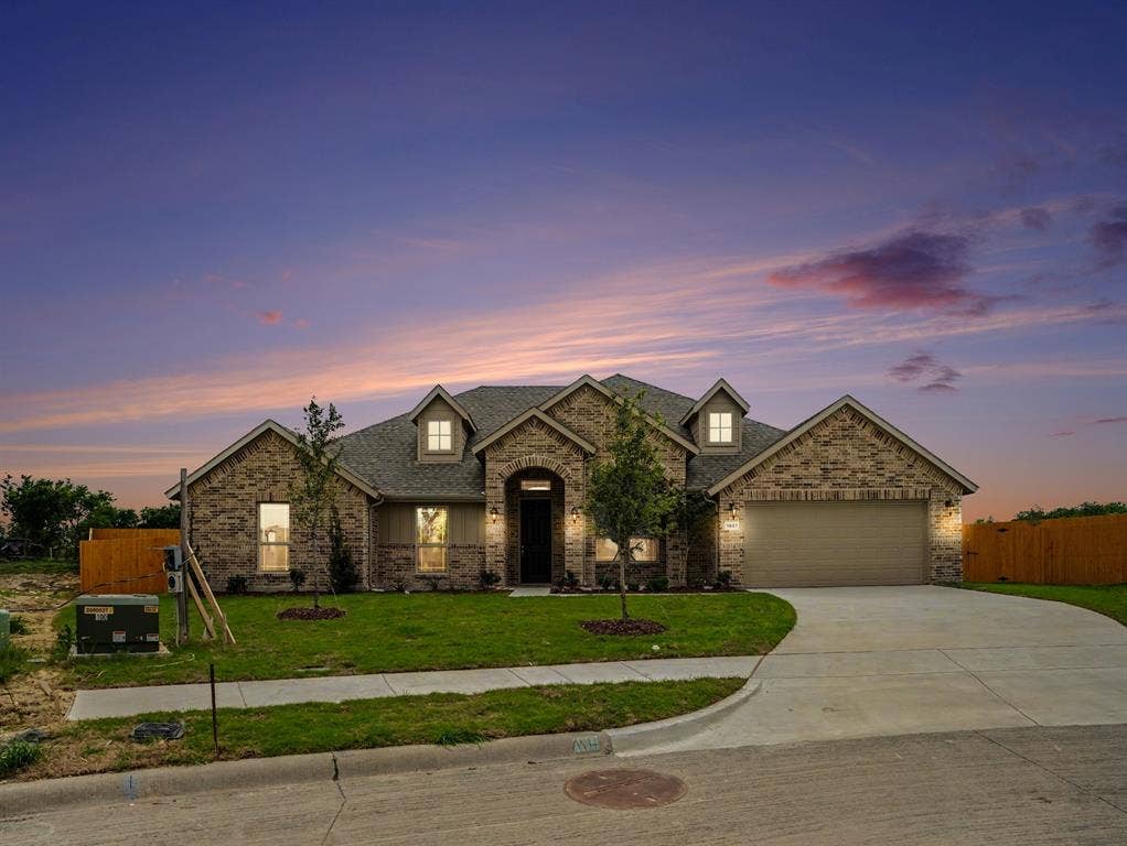 Single-story residence featuring a brick facade with stone accents and a gabled roofline