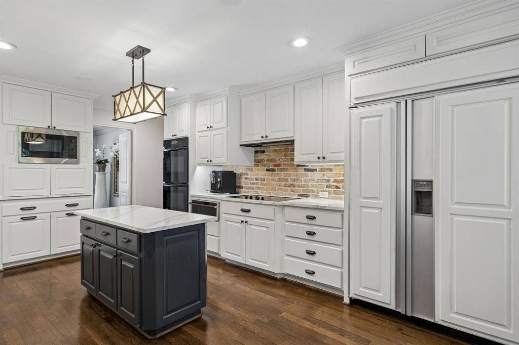 6829 Midcrest Drive, Dallas, TX 75254 Kitchen with Quartz countertops and brick backslash. Built in Subzero Refrigerator.
