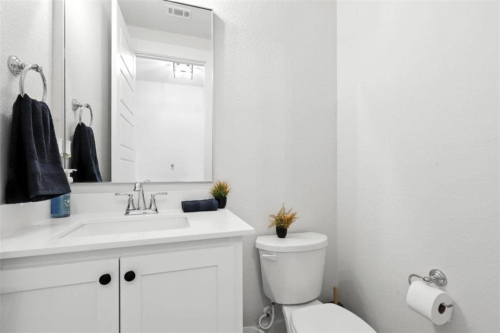 3141 Claire Drive, Midlothian, TX 76065 Bathroom featuring a white vanity with integrated sink, chrome faucet, and rectangular mirror