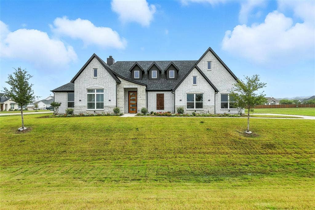 3141 Claire Drive, Midlothian, TX 76065 Contemporary brick exterior with dark trim accents, a prominent front gable, a multi-pane wood-finish entry door, and a spacious green lawn