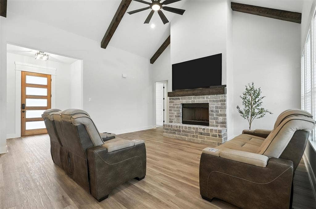 3141 Claire Drive, Midlothian, TX 76065 Spacious living area featuring a vaulted ceiling with exposed wood beams, a ceiling fan, and wood-finish flooring