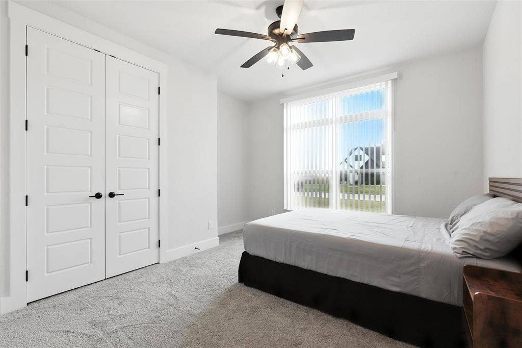 3141 Claire Drive, Midlothian, TX 76065 White paneled bi-fold closet doors with black hardware, complementing light gray carpeting