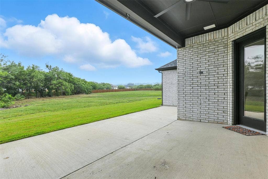 3141 Claire Drive, Midlothian, TX 76065 Covered patio featuring a ceiling fan, light gray brick exterior, and a glass-paneled door