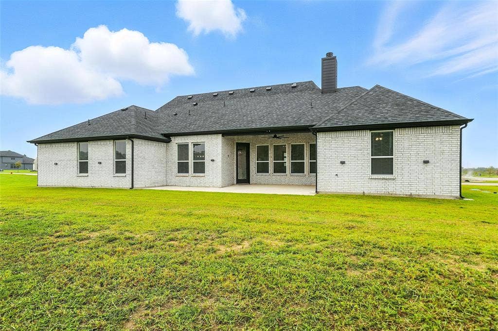 3141 Claire Drive, Midlothian, TX 76065 White brick exterior with a dark shingle roof and a concrete patio