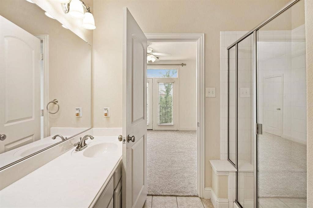 5717 PANTHEON Court, Plano, TX 75024 Bathroom featuring a single vanity with an integrated sink, brushed nickel faucet, and overhead three-bulb light fixture