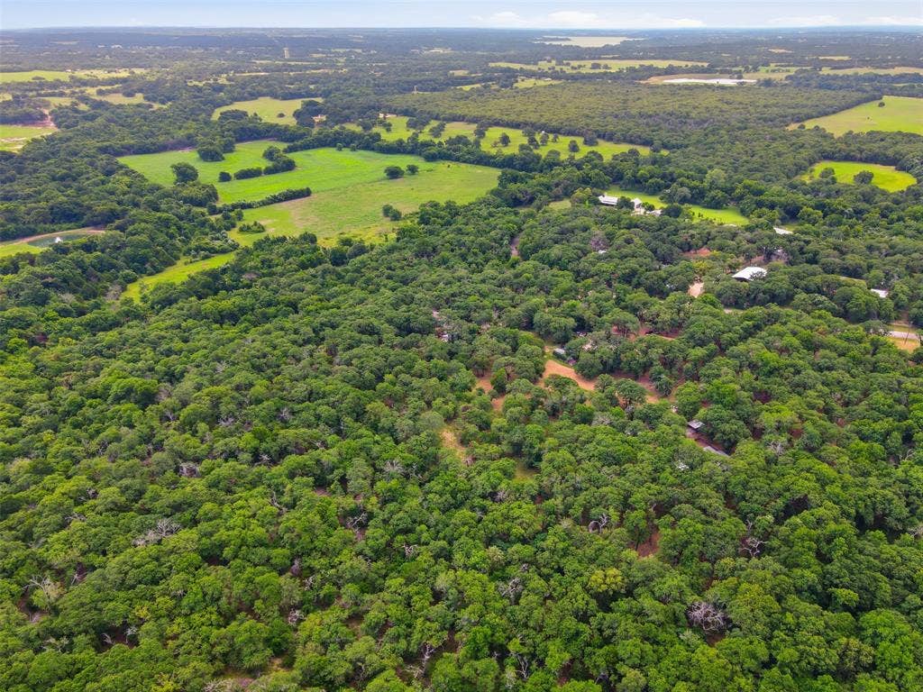 777 Wildwood Trail, Weatherford, TX 76085 Expansive aerial view showcasing significant tree coverage with interspersed cleared land areas