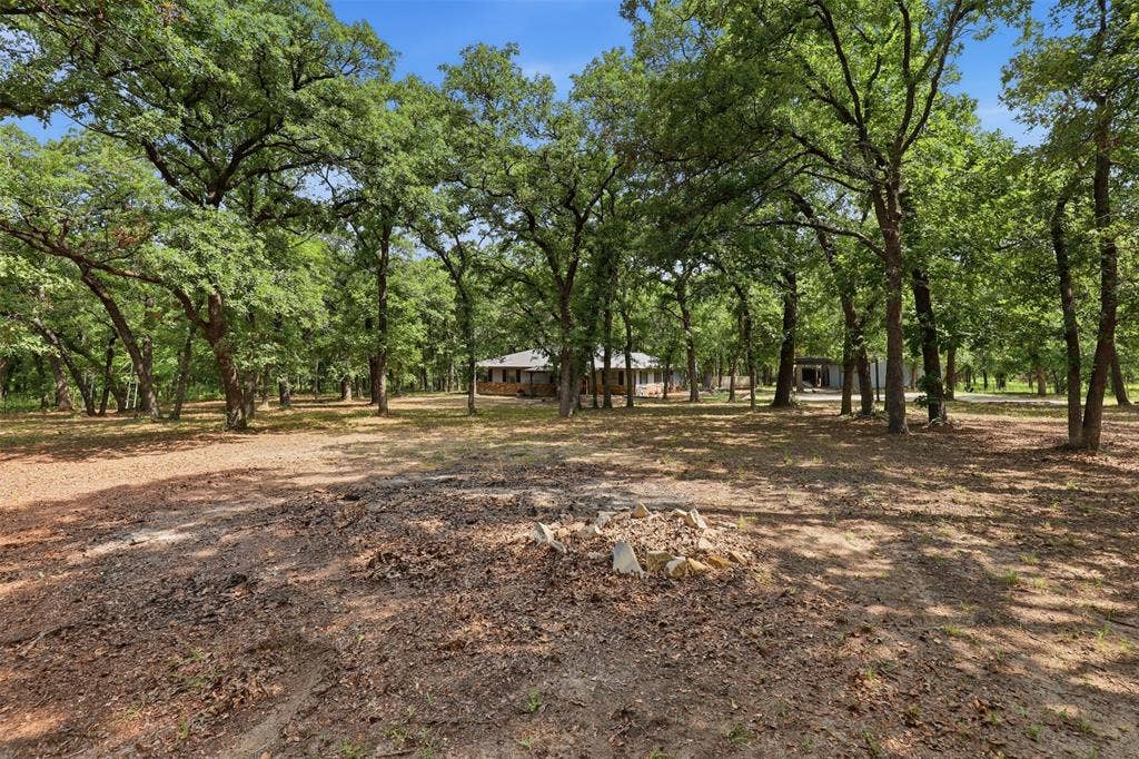 777 Wildwood Trail, Weatherford, TX 76085 Wooded grounds with mature trees surrounding a brick-exterior residence