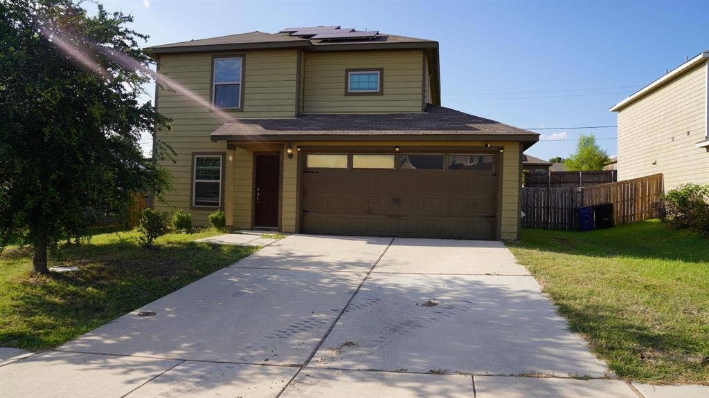 1321 Eagle Lake Drive, Azle, TX 76020 Two-story residence featuring light olive siding and a dark brown garage door with upper window inserts