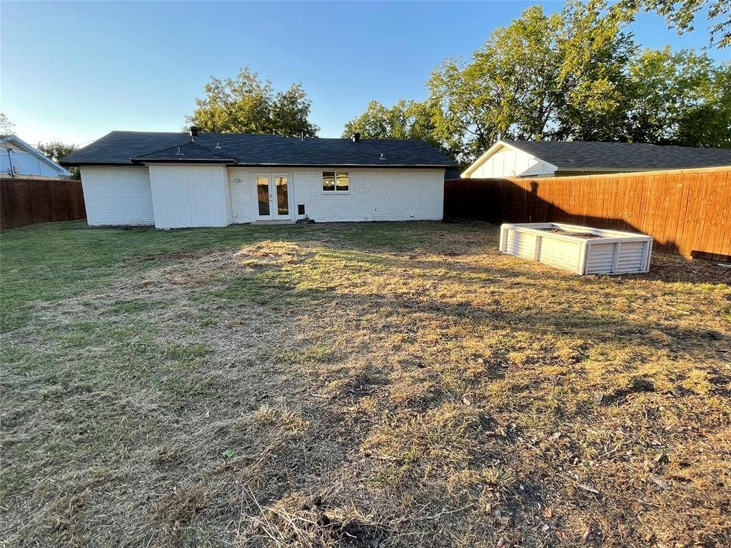 822 Johnnie Row, Seagoville, TX 75159 Rear view of house featuring a lawn and french doors