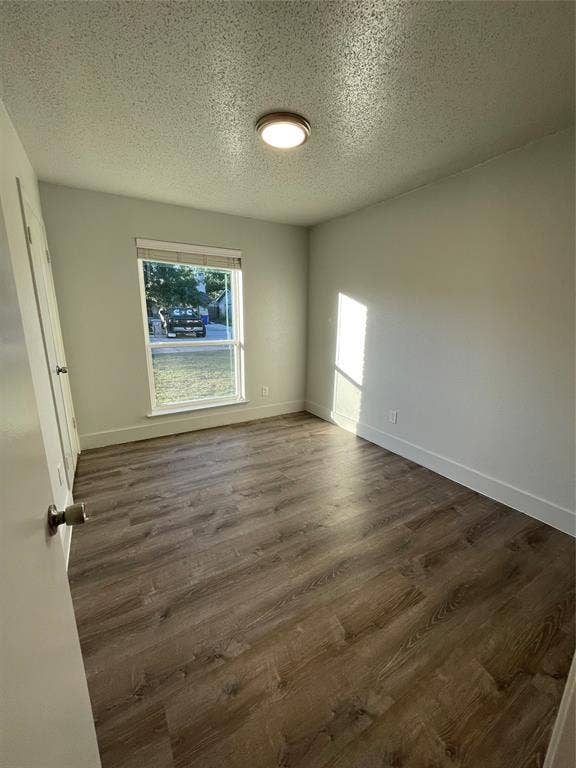 822 Johnnie Row, Seagoville, TX 75159 Spare room featuring a textured ceiling and dark hardwood / wood-style flooring