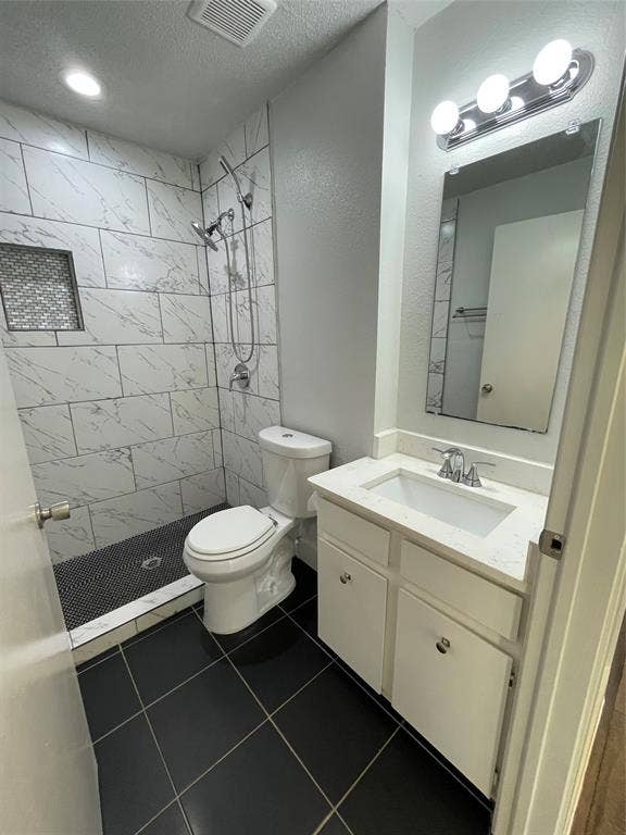 822 Johnnie Row, Seagoville, TX 75159 Bathroom with tile patterned floors, toilet, vanity, and tiled shower