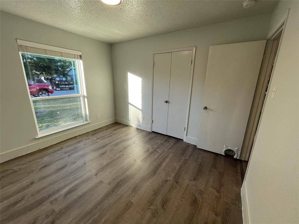 822 Johnnie Row, Seagoville, TX 75159 Unfurnished bedroom with a textured ceiling, hardwood / wood-style floors, and a closet
