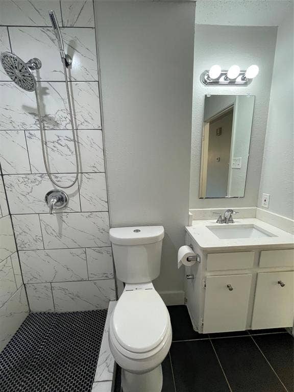 822 Johnnie Row, Seagoville, TX 75159 Bathroom featuring vanity, tile patterned floors, toilet, and tiled shower