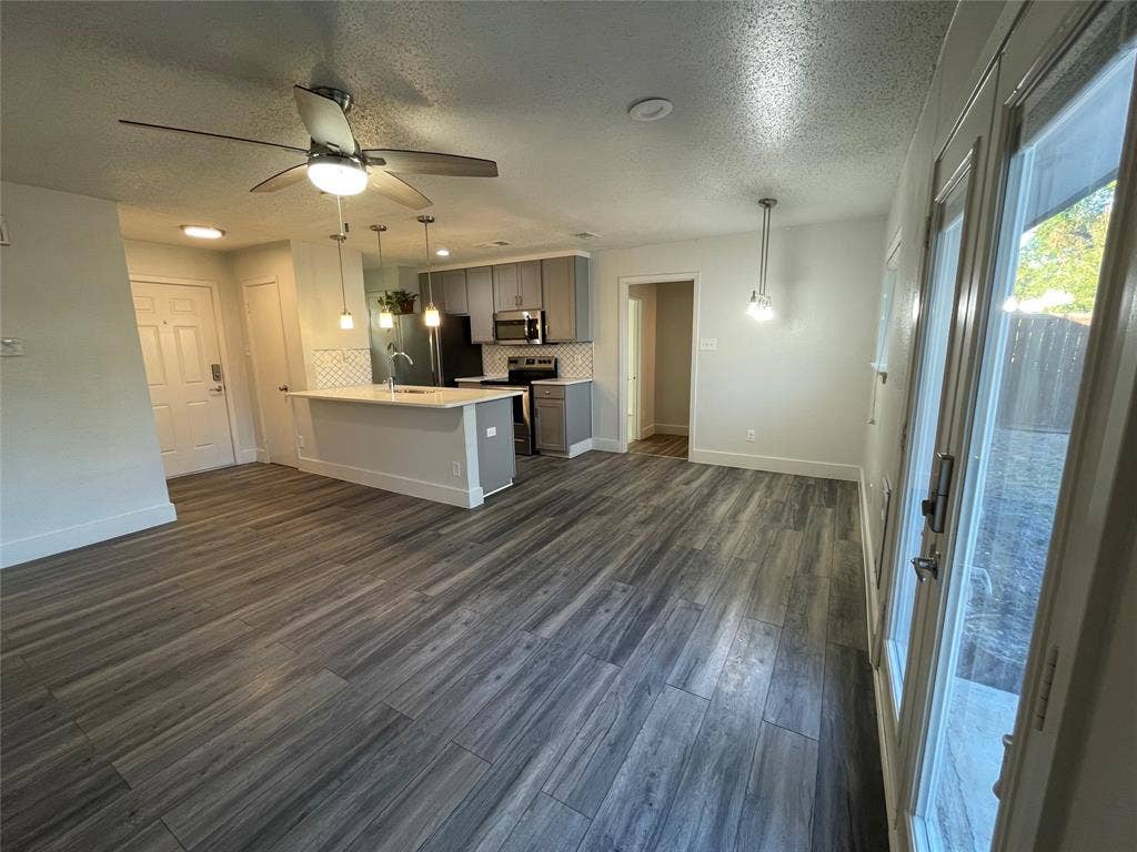 822 Johnnie Row, Seagoville, TX 75159 Kitchen with appliances with stainless steel finishes, hanging light fixtures, decorative backsplash, and dark wood-type flooring