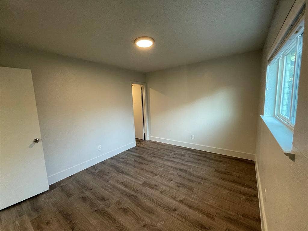 822 Johnnie Row, Seagoville, TX 75159 Unfurnished room with a textured ceiling and dark hardwood / wood-style flooring