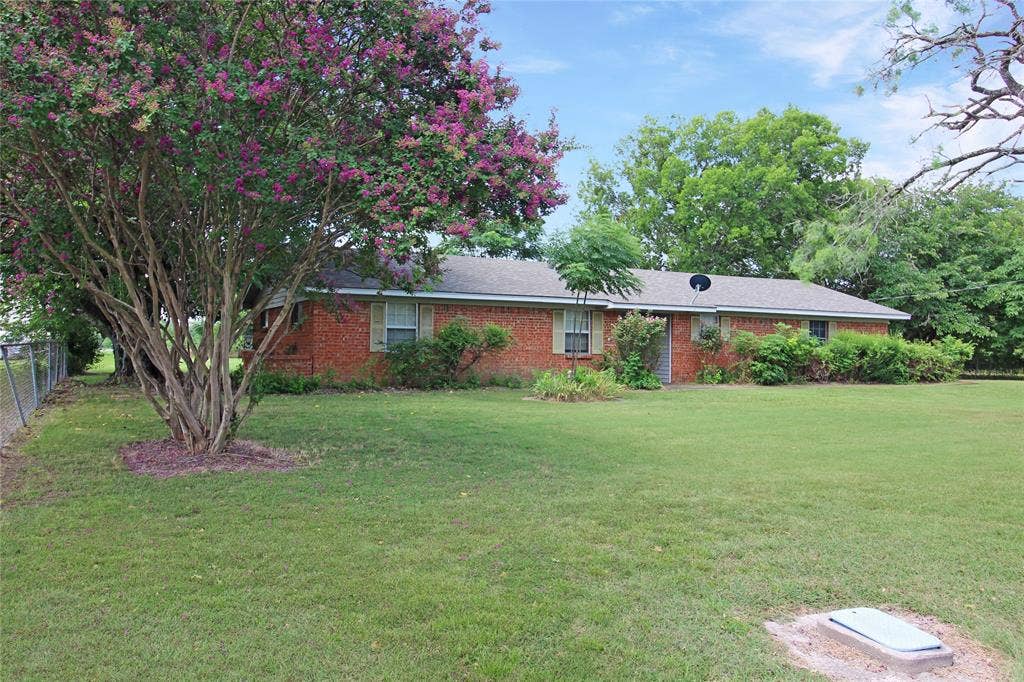 8769 S Fm 148, Scurry, TX 75158 Brick ranch-style residence featuring a prominent flowering crape myrtle tree