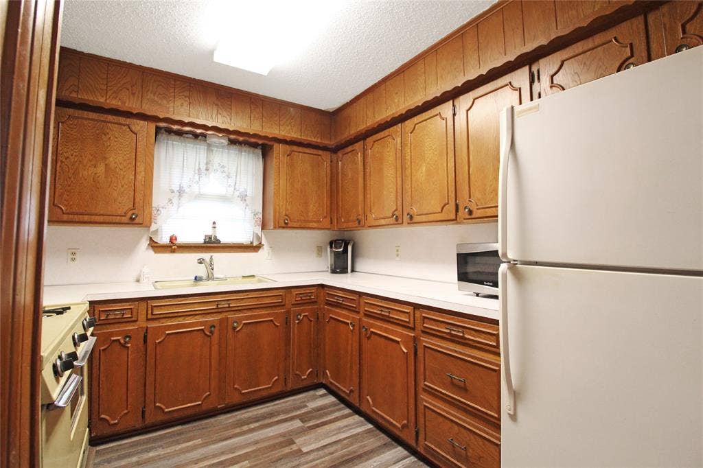 8769 S Fm 148, Scurry, TX 75158 Kitchen featuring wood cabinetry, white countertops, a double-basin sink, and wood-finish flooring