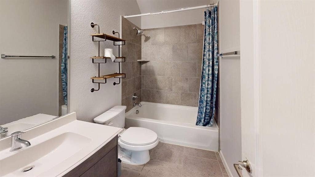 Bathroom featuring a white vanity with an integrated sink, chrome faucet, and expansive wall mirror