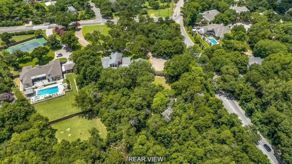2825 Lake Air Drive, Waco, TX 76710 Expansive, tree-lined property featuring a large residence with a private swimming pool, surrounding patio, and a vast lawn area