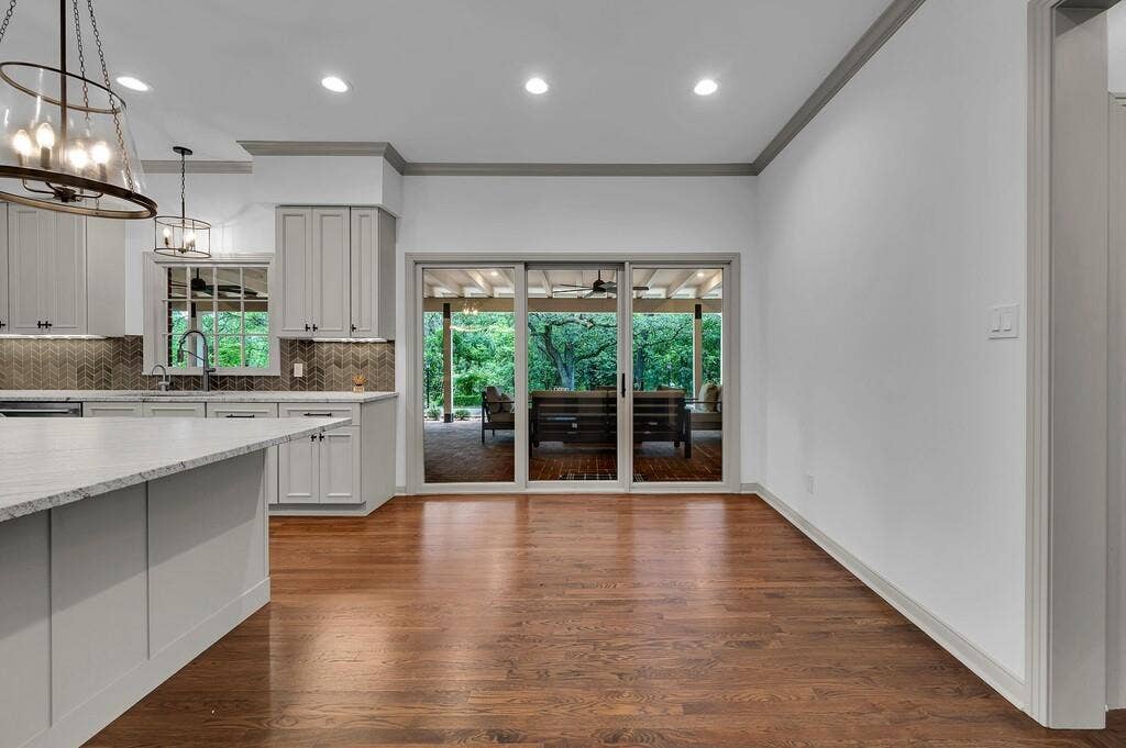 2825 Lake Air Drive, Waco, TX 76710 Kitchen area featuring a large center island with a light-toned countertop, gray shaker-style cabinetry, and a herringbone pattern tile backsplash
