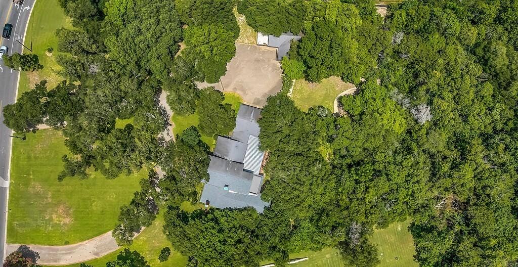 2825 Lake Air Drive, Waco, TX 76710 Expansive property featuring a multi-level roofline, extensive mature tree cover, and a large paved parking area