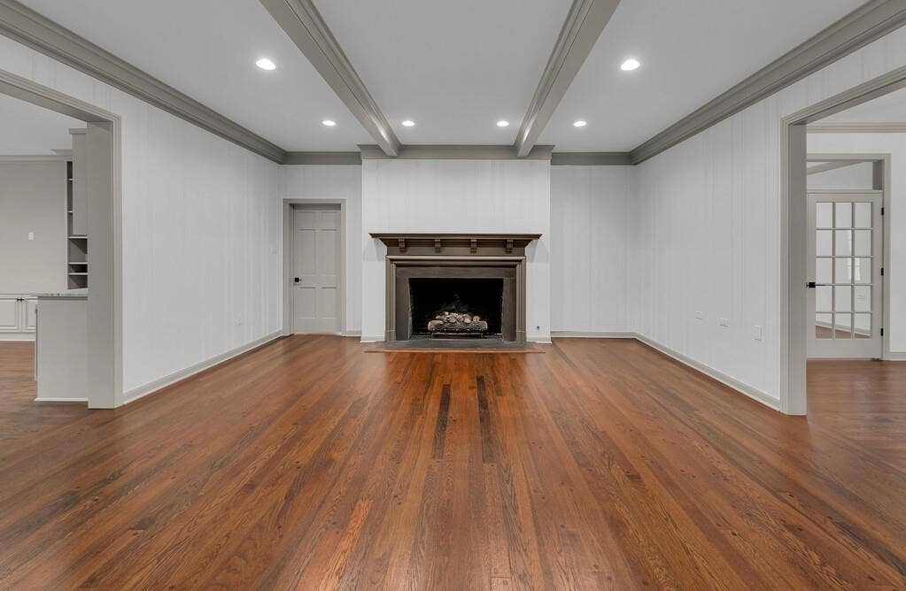 2825 Lake Air Drive, Waco, TX 76710 Spacious interior featuring wood-finish flooring, a central fireplace with an ornate mantel, recessed lighting, and crown molding
