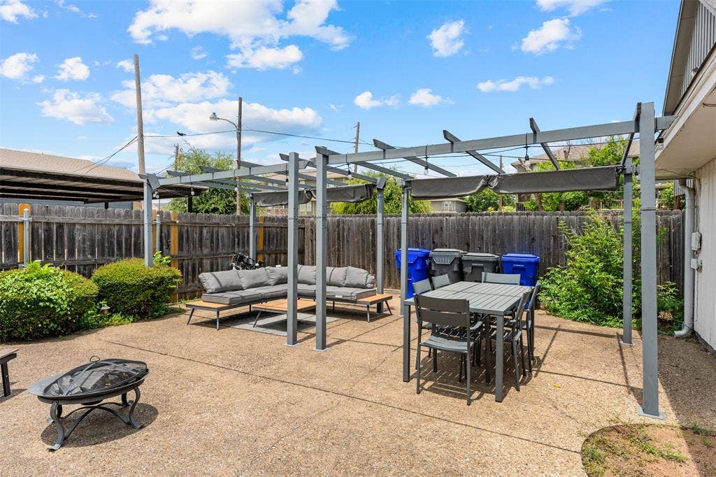 1405 Speight Avenue, #1, Waco, TX 76706 Expansive concrete patio featuring a modern metal pergola with retractable sunshades, offering dedicated outdoor dining and lounging areas