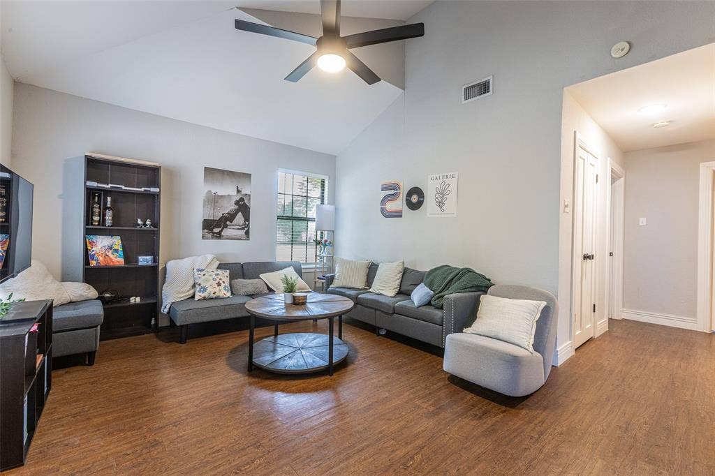 1405 Speight Avenue, #1, Waco, TX 76706 Living space featuring a vaulted ceiling with a ceiling fan, wood-finish flooring, a double window with blinds, and white baseboards