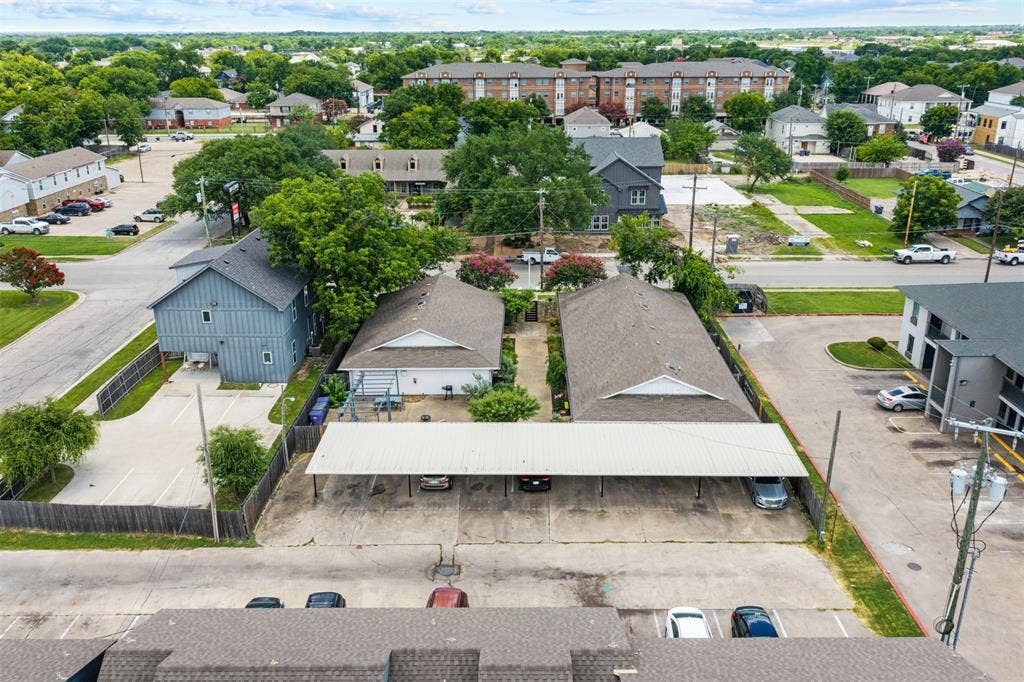 1405 Speight Avenue, #1, Waco, TX 76706 Aerial perspective showcasing multiple properties, including a multi-story building with light blue siding, a single-story building with a light-colored exterior, and a large carport structure