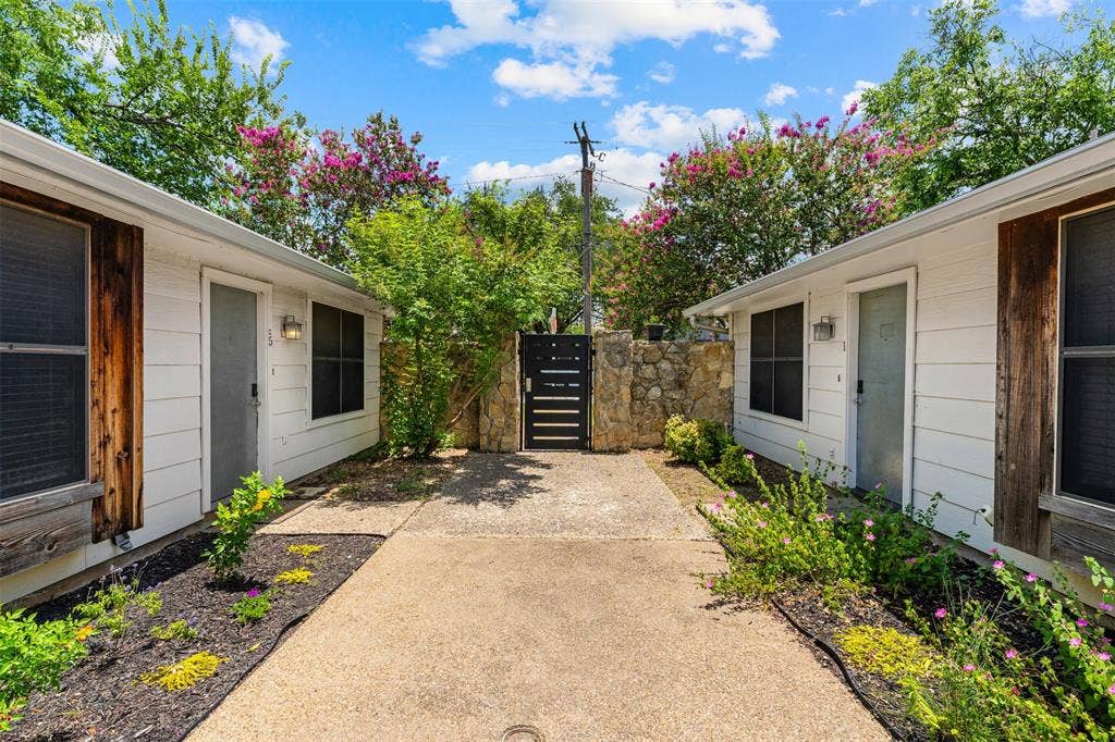 1405 Speight Avenue, #1, Waco, TX 76706 Central courtyard featuring a concrete walkway, stone wall, and dark metal gate