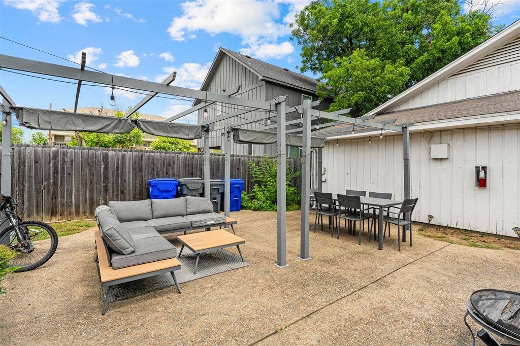 1405 Speight Avenue, #1, Waco, TX 76706 Spacious concrete patio featuring a metal pergola with retractable fabric canopies and string lighting