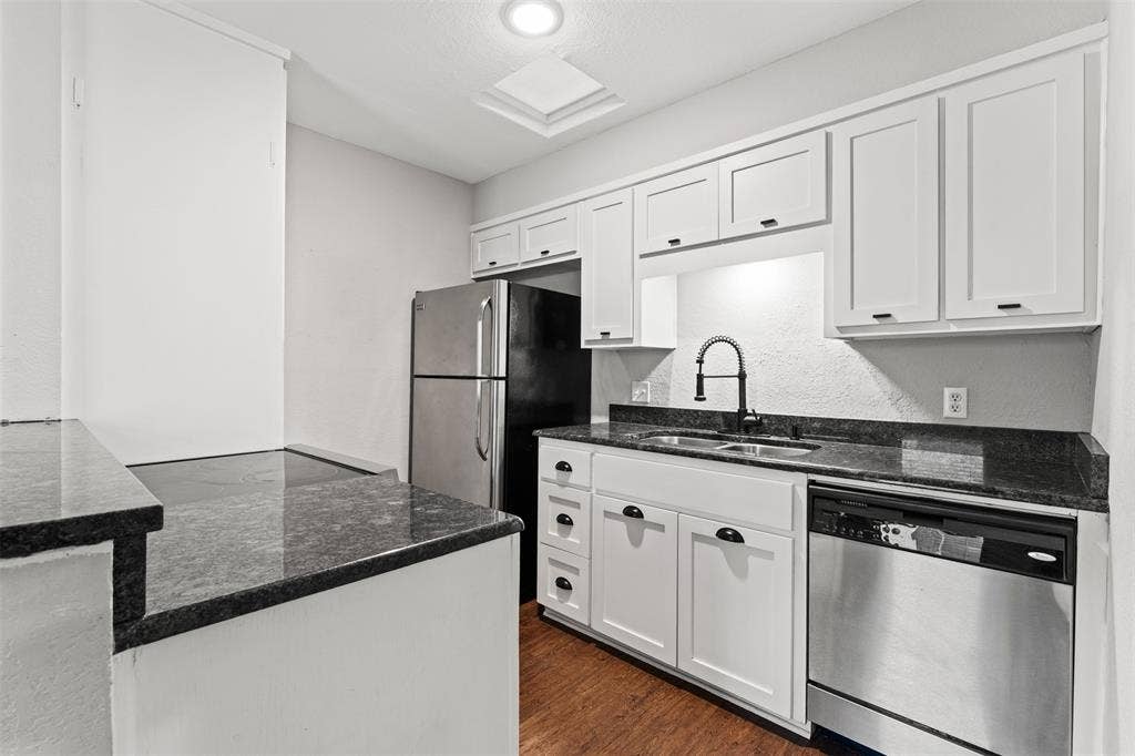 1405 Speight Avenue, #1, Waco, TX 76706 Kitchen featuring white cabinetry, dark granite countertops, stainless steel appliances, and wood-finish flooring