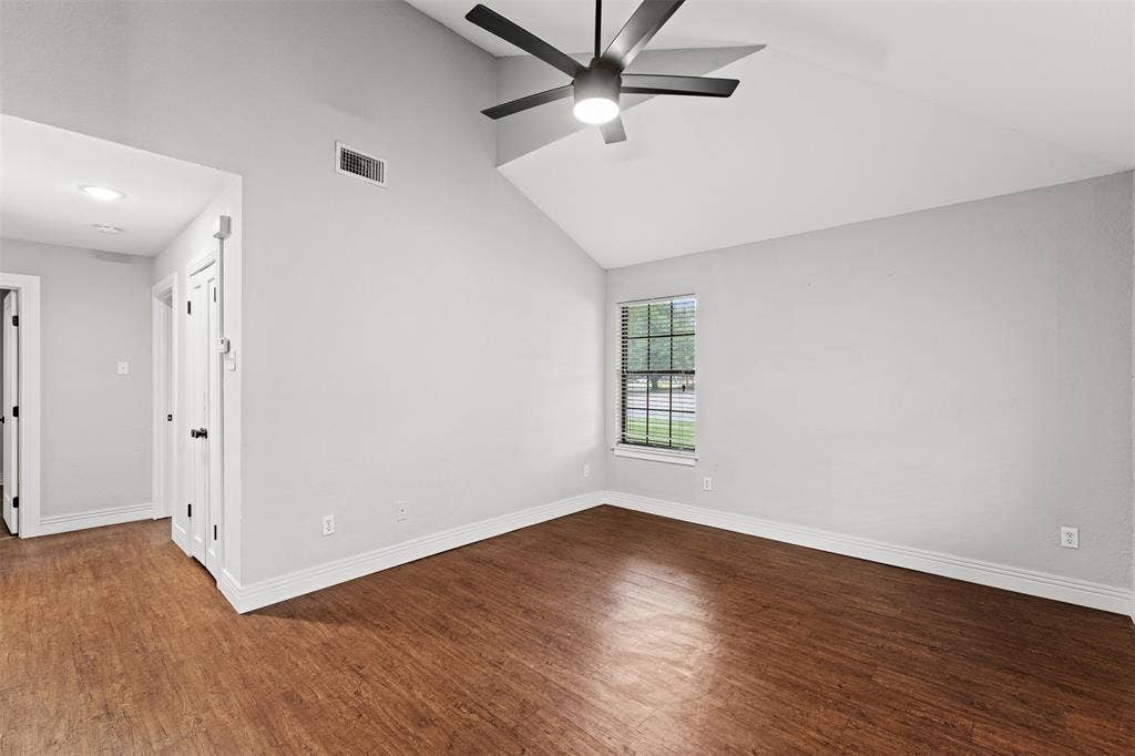 1405 Speight Avenue, #1, Waco, TX 76706 Vaulted ceiling room featuring wood-finish flooring, a contemporary ceiling fan with integrated lighting, window with blinds, and white trim