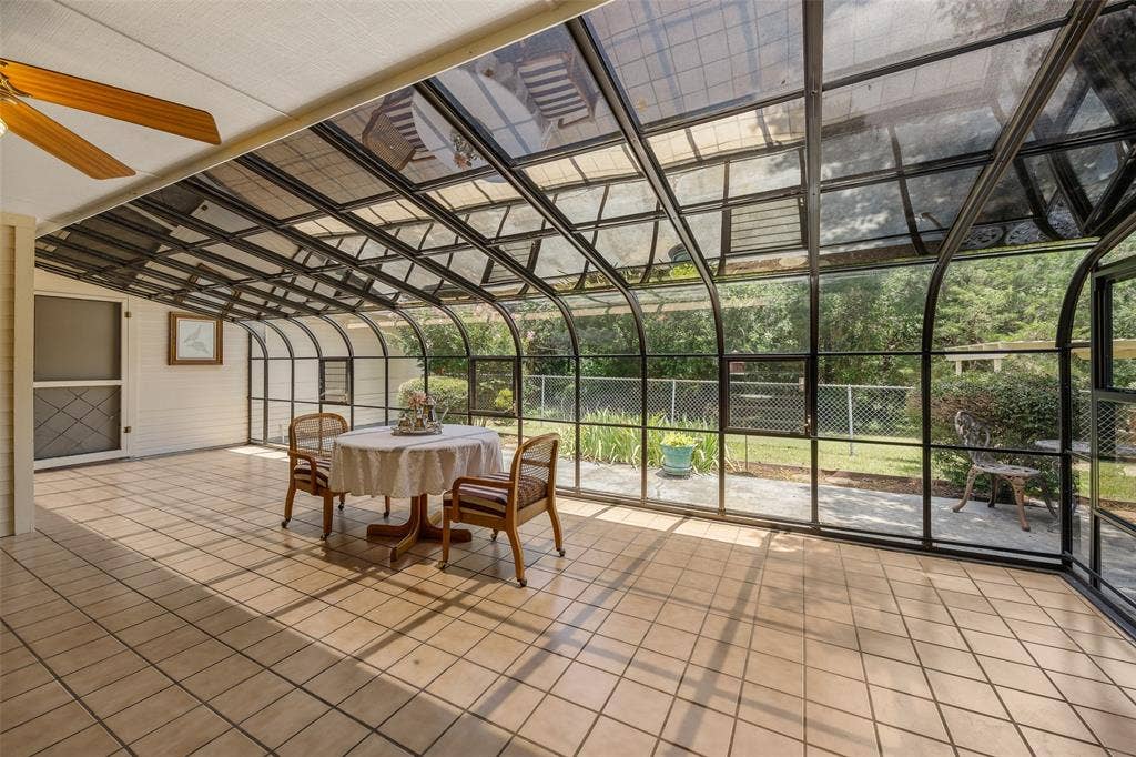 205 Covey Lane, McKinney, TX 75071 Expansive sunroom featuring a vaulted glass ceiling, full-height glass walls, and light-toned tile flooring