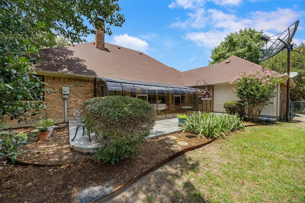 205 Covey Lane, McKinney, TX 75071 Brick exterior with a sunroom addition and a brown shingle roof