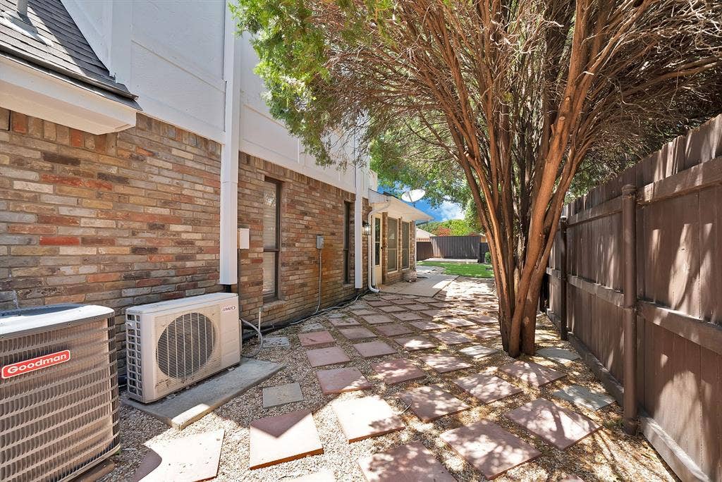 4021 San Mateo Drive, Plano, TX 75093 Side yard featuring a stone paver pathway, gravel ground cover, mature tree, and a wood privacy fence
