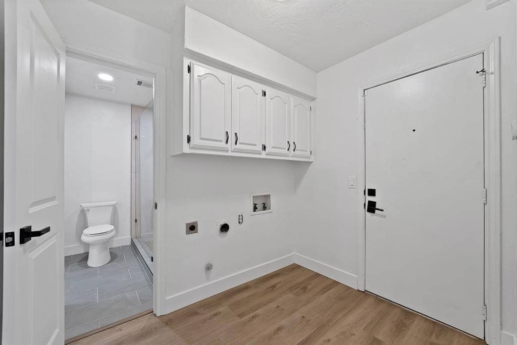 4021 San Mateo Drive, Plano, TX 75093 Utility area featuring wood-finish flooring, white cabinetry with black hardware, and laundry hookups