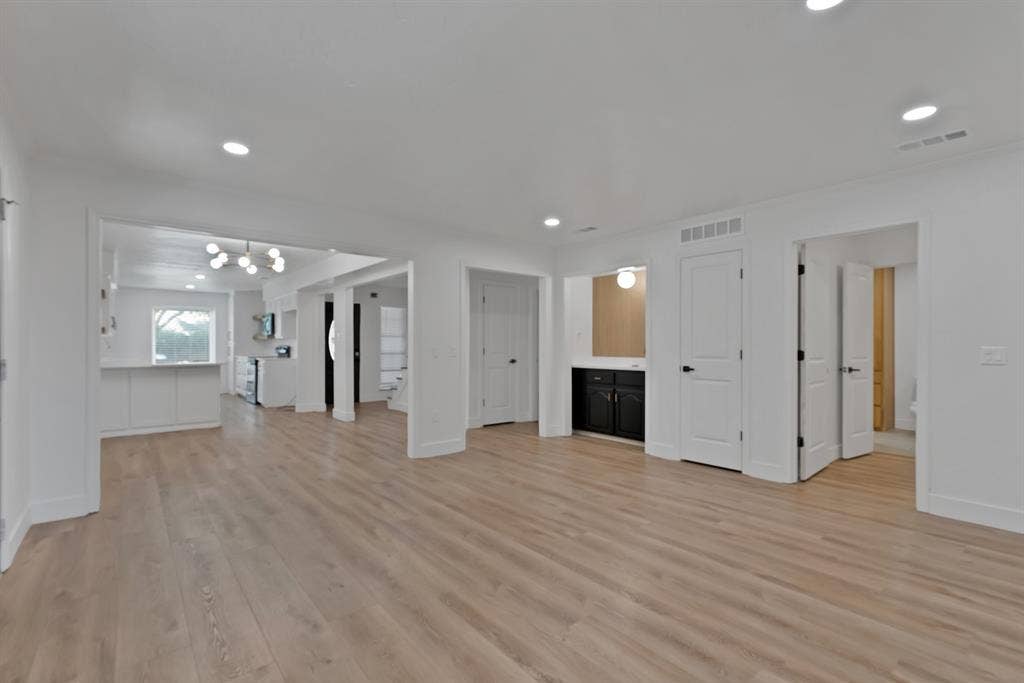 4021 San Mateo Drive, Plano, TX 75093 Spacious room featuring wood-finish flooring, recessed lighting, and a modern chandelier