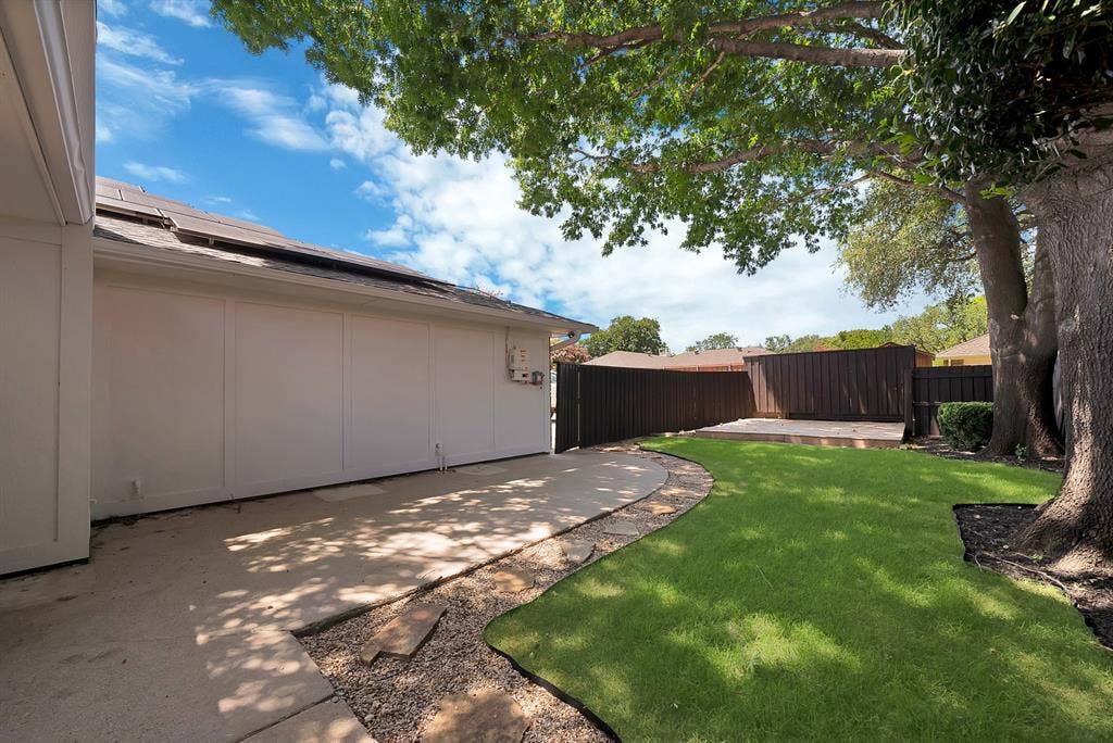 4021 San Mateo Drive, Plano, TX 75093 Private backyard featuring a wooden privacy fence, a raised wooden deck, and a mature shade tree